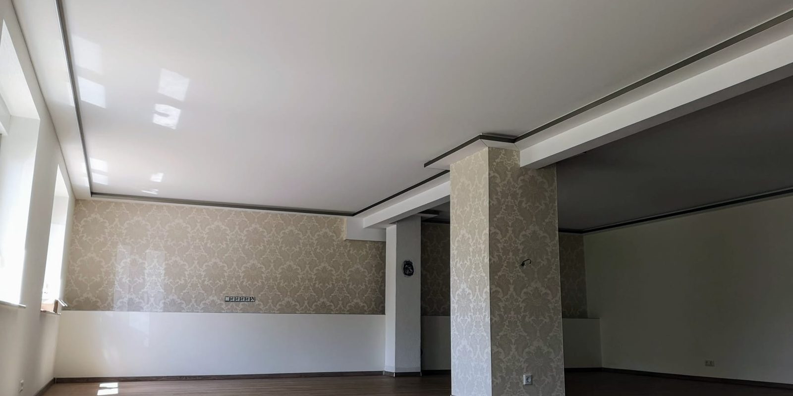 Großer Raum mit glänzender Spanndecke bei Tageslicht